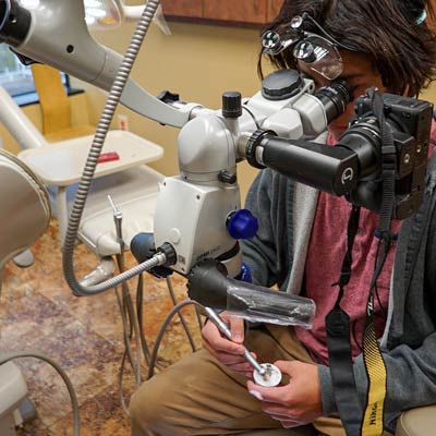 Drilling a hole in the tooth under a dental microscope.